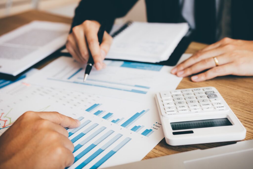 Financial advisors collaborating on a strategy in a modern office setting, analyzing financial data and charts, discussing investment plans, and providing expert financial advice.